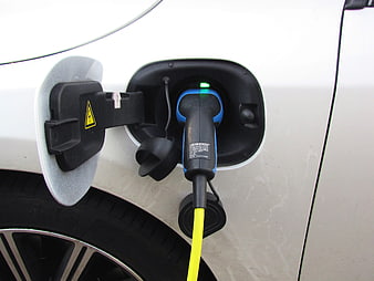 Close-up of electric vehicle charging port with plug connected