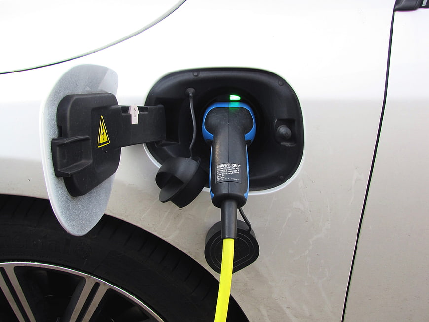 Close-up of electric vehicle charging port with plug connected