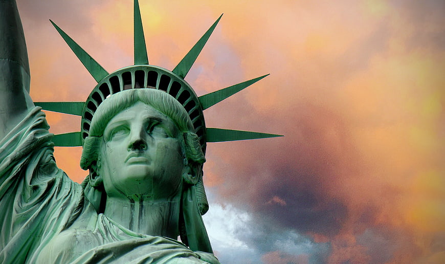 Statue of Liberty Head Against Dramatic Sunset Sky
