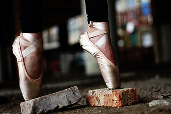 Ballerina Pointe Shoes on Broken Bricks in Urban Setting
