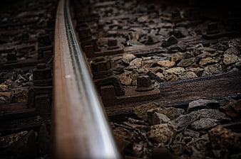 Close-up of rusty railroad tracks with gravel and wooden ties
