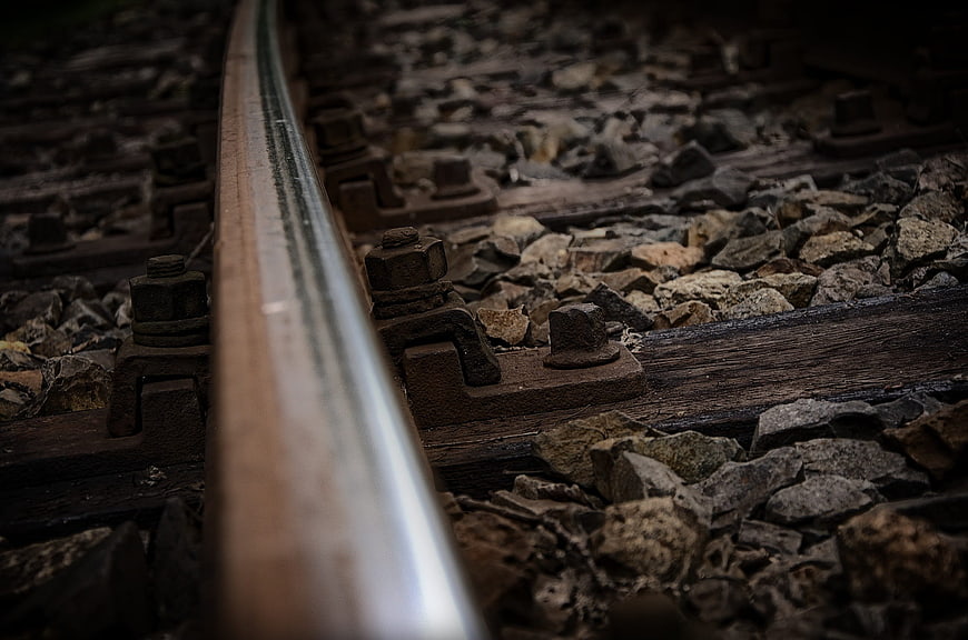 Close-up of rusty railroad tracks with gravel and wooden ties