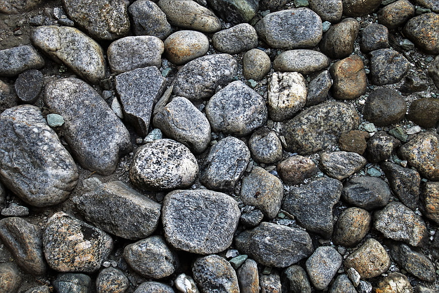 Close-up texture of gray and brown cobblestone pavement surface