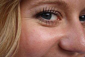 Close-up of mature woman's eye with wrinkles and blonde hair