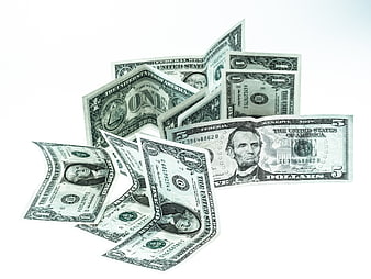 Scattered US Dollar Bills on White Background