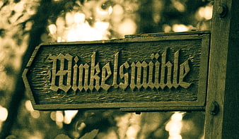 Vintage wooden sign reading Blinkelsmühle in forest