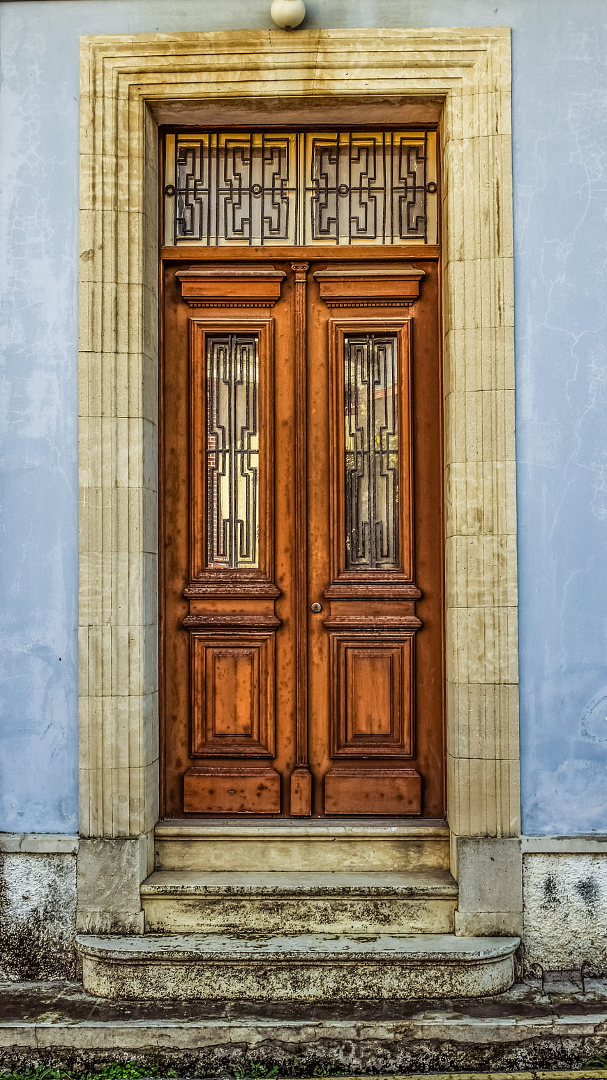 Vintage Wooden Double Door with Stone Frame on Blue Wall