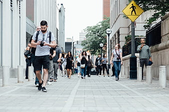 Pedestrians walking on urban city street with camera
