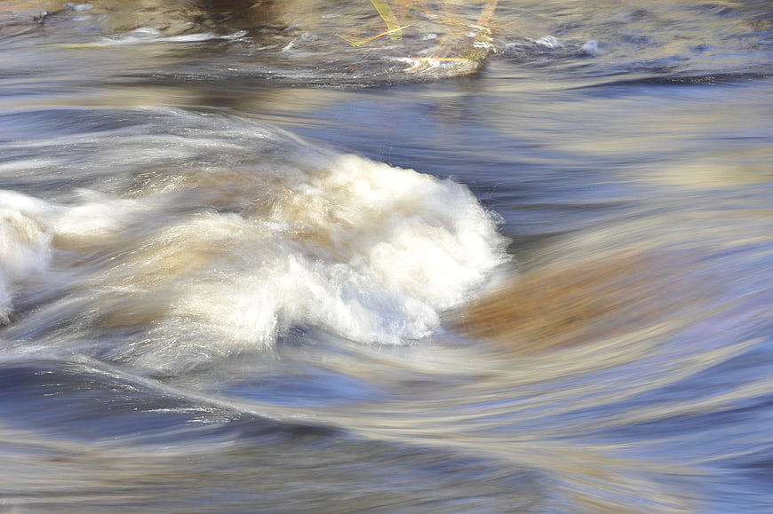 Abstract Flowing River Water Surface With White Foam And Motion Blur