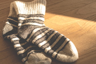 Cozy Striped Wool Socks on Wooden Floor in Sunlight