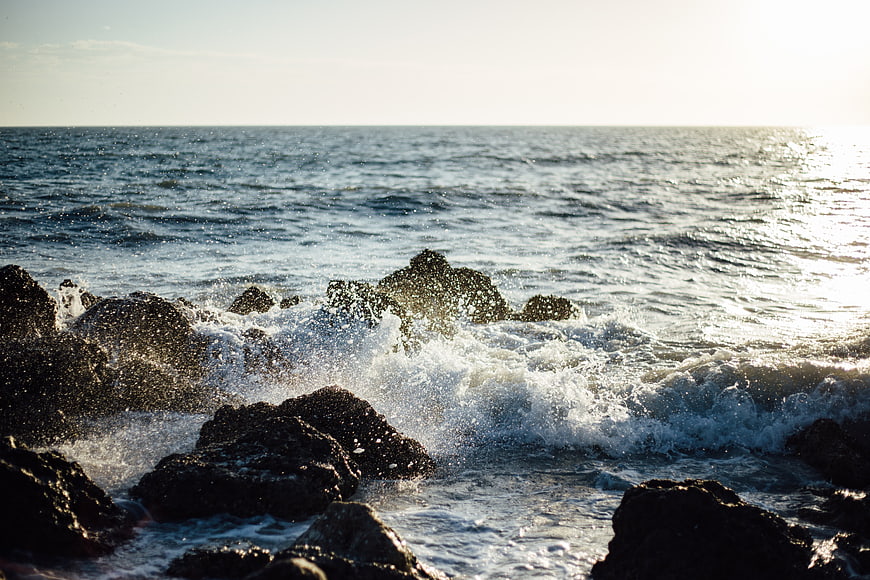 Ocean Waves Crashing on Rocky Shore at Sunset