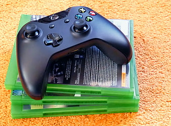 Black Xbox Controller on Green Game Cases