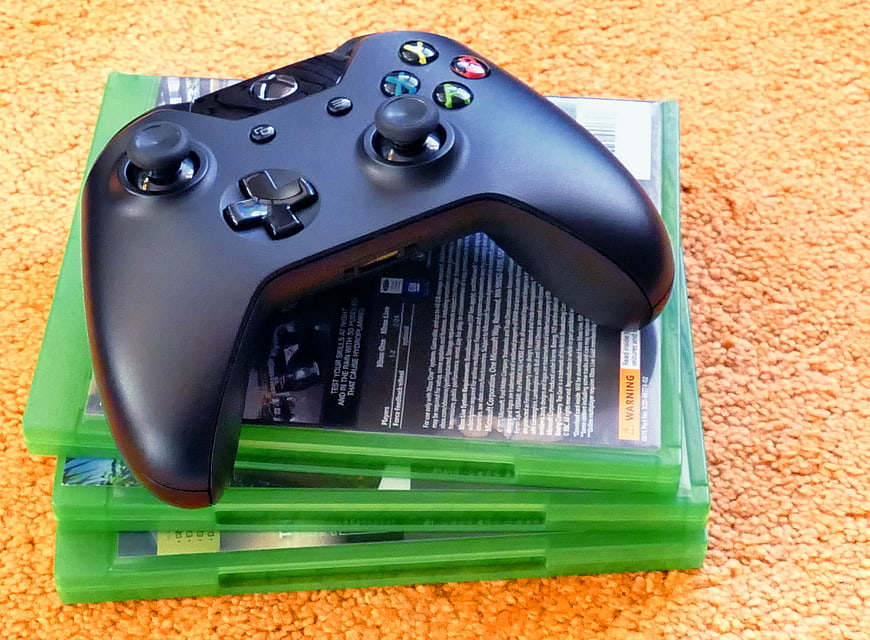 Black Xbox Controller on Green Game Cases