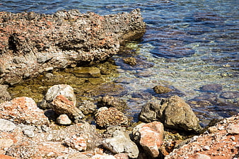 Clear Blue Sea Water Washing Over Rocky Coastal Shoreline