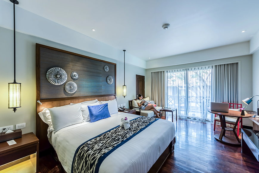 Modern Hotel Bedroom Interior with Woman Relaxing
