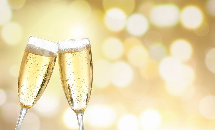 Two Champagne Glasses Toasting Against Golden Bokeh Background