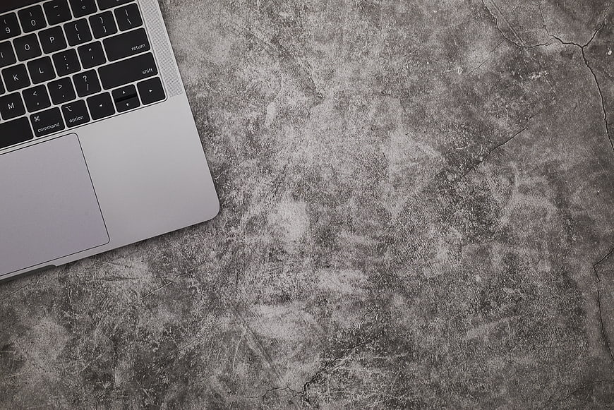 Silver Laptop on Textured Concrete Surface with Copyspace