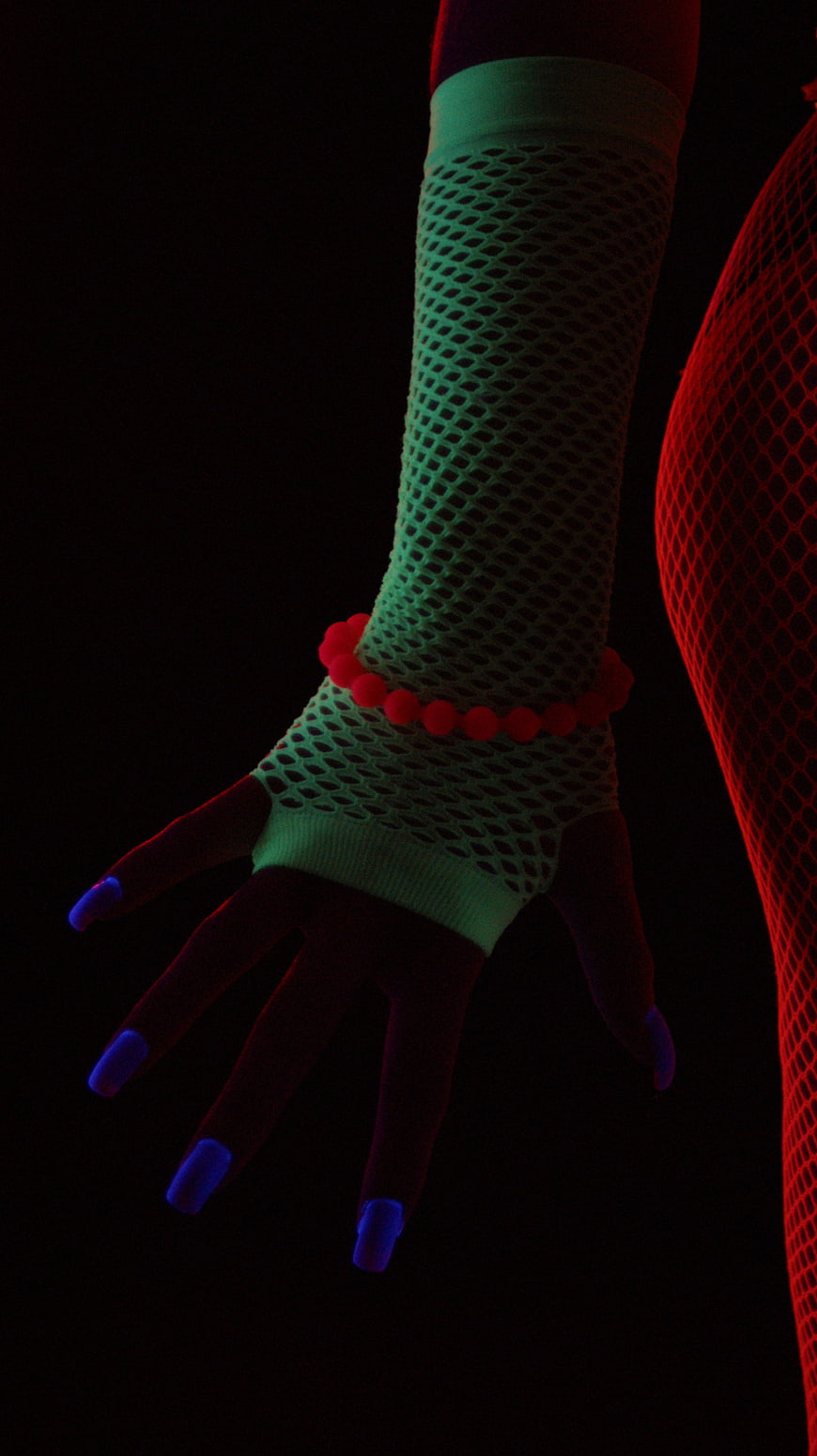 Neon lit fishnet glove hand with glowing nails