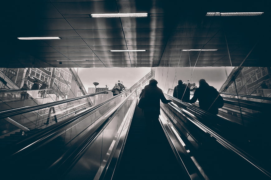 Silhouetted Commuters on Escalators in Modern Urban Metro Station