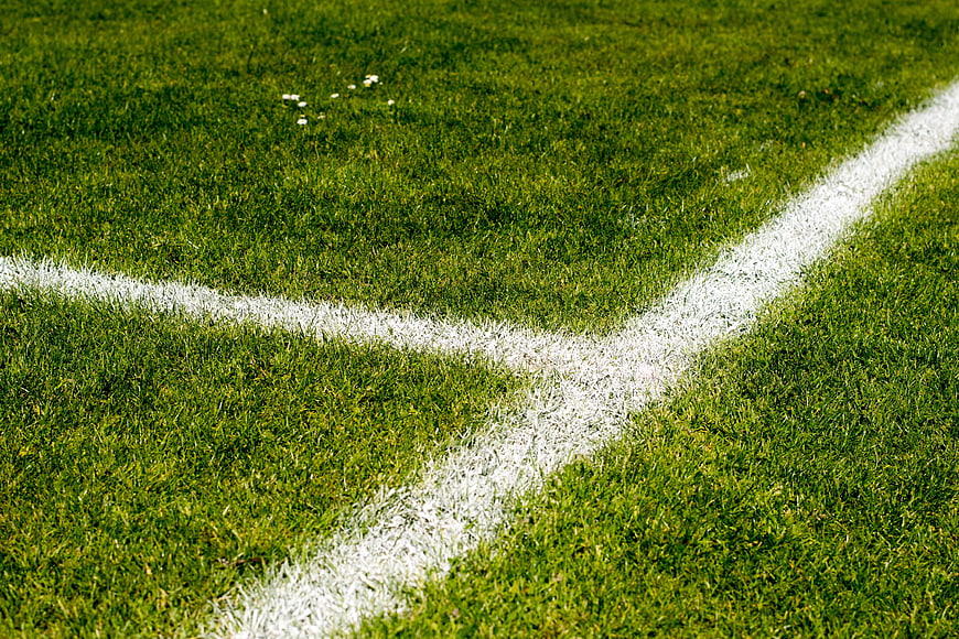 Close-up of white corner lines on a green football pitch