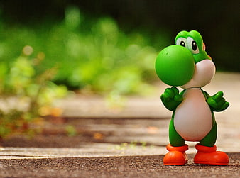 Yoshi Figure Toy on Wooden Surface with Green Background