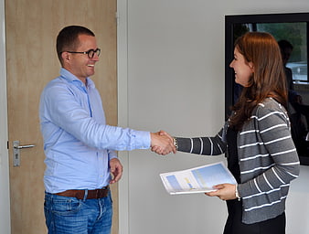 Businessman and woman shaking hands in office