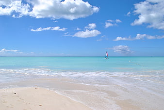 Tropical Caribbean Beach With Turquoise Water And Sailboat