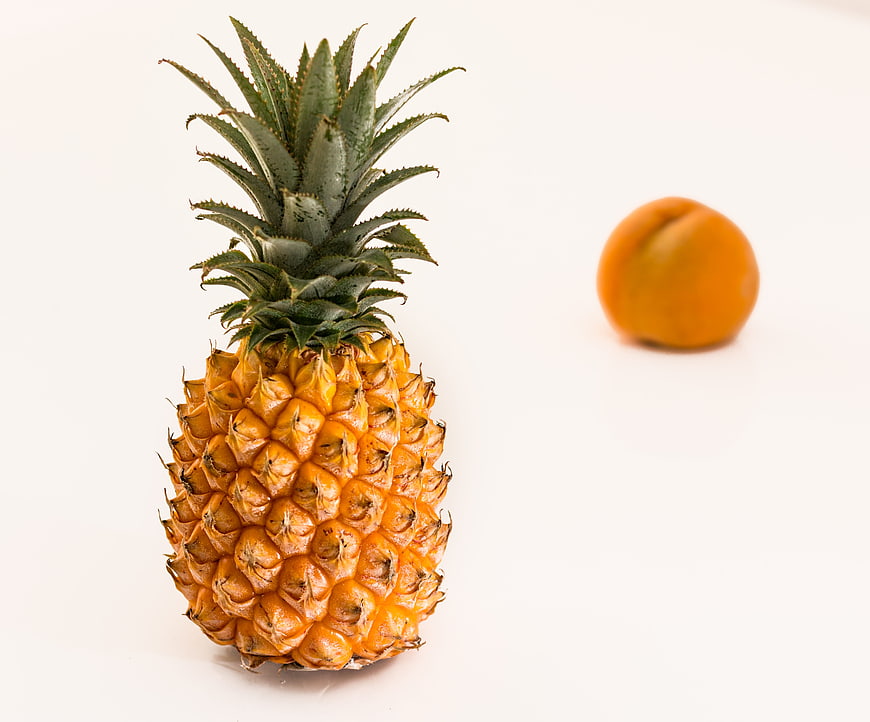 Fresh pineapple and apricot on white background