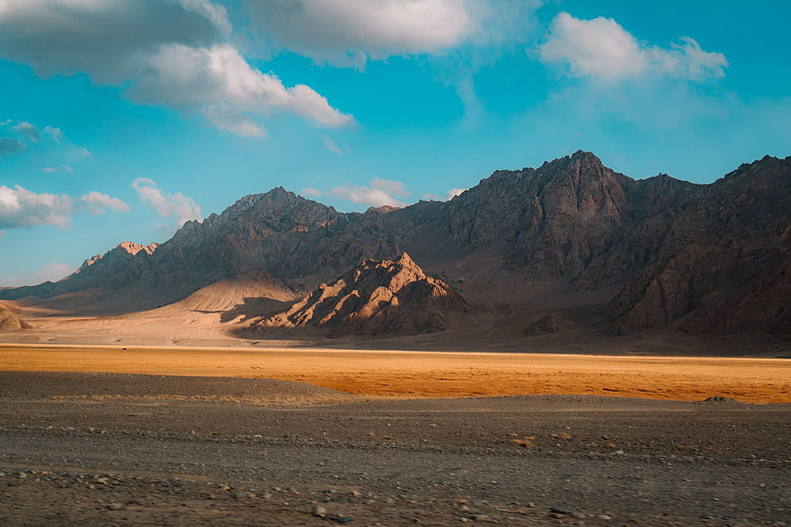 Vast desert landscape with rugged mountains and blue sky