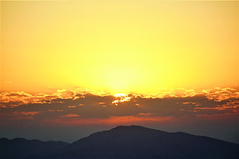 Golden Sunrise Over Silhouetted Mountain Range