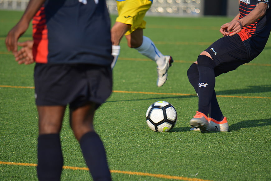 Soccer players competing for the ball on a green field