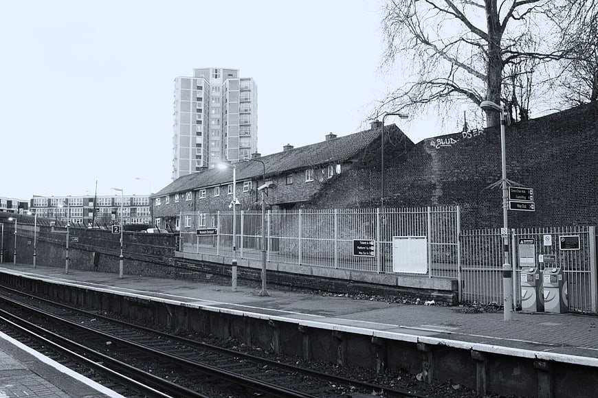 Black and white urban train station platform with tracks