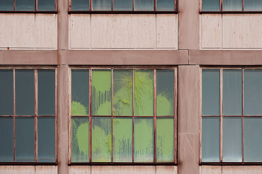 Abstract Green Paint Splatter on Building Window Panes