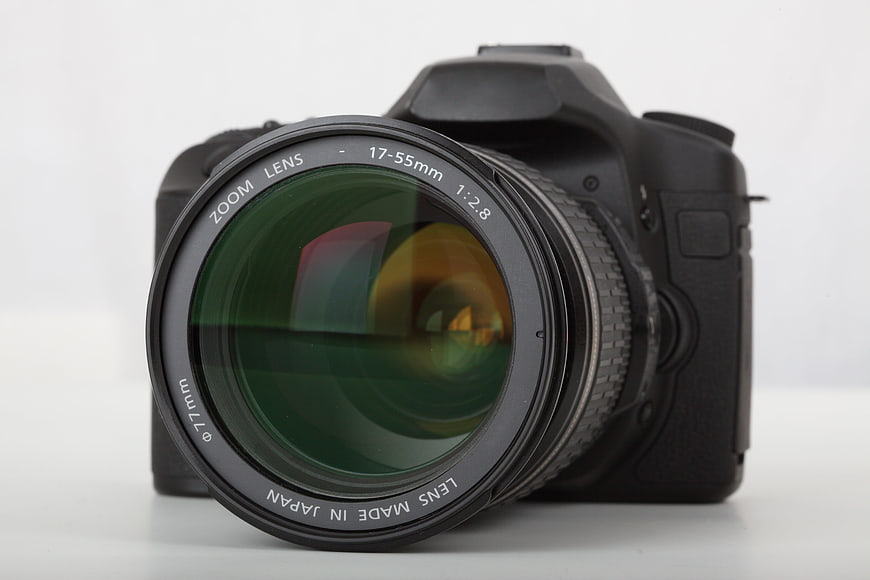 Black DSLR Camera With 17-55mm Zoom Lens On White Background
