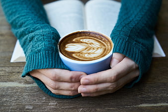 Cozy Hands Holding Coffee Cup with Open Book