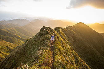 Woman hiking on mountain ridge at sunrise