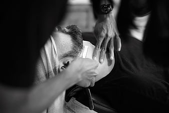 Barber Shaving Customer With Straight Razor In Black And White