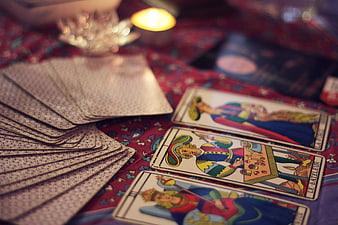 Tarot cards spread on red cloth with candlelight