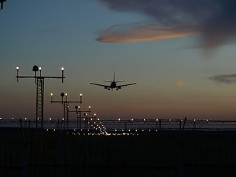 Silhouette of Airplane Landing at Airport at Dusk