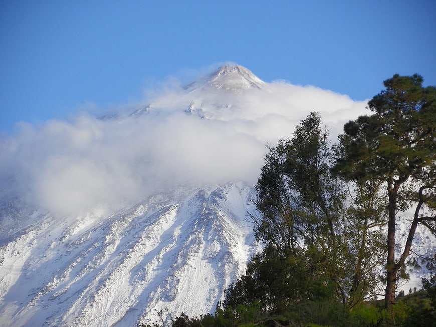Snow-Capped Mount Teide Volcano with Clouds and Pine Trees