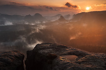 Misty Mountain Sunrise Over Rocky Cliff Edge