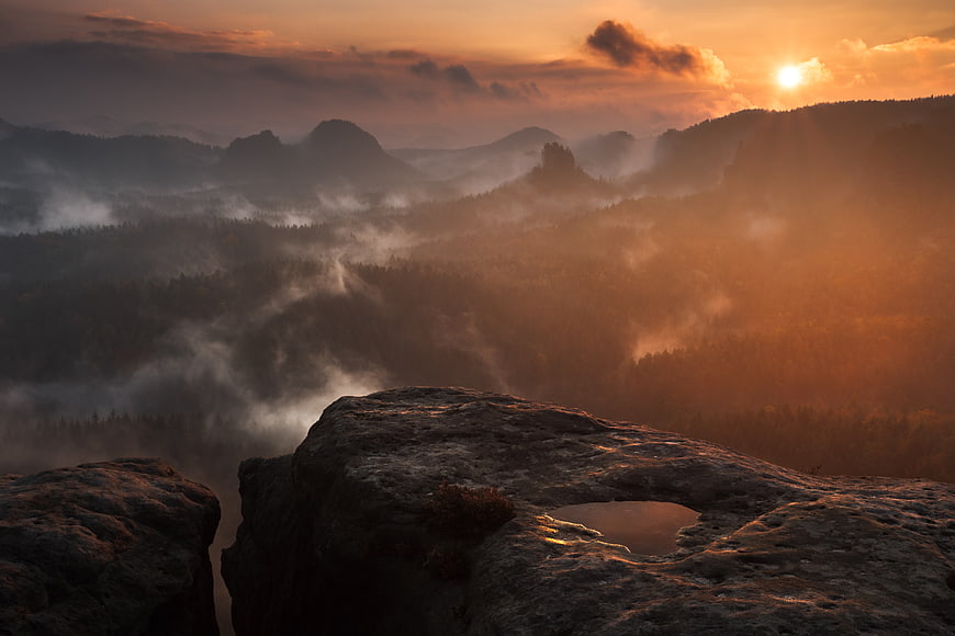 Misty Mountain Sunrise Over Rocky Cliff Edge