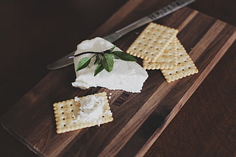 Fresh white cheese and crackers on wooden board