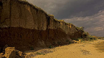 Dramatic Erosion Cliff Face Under Stormy Sky