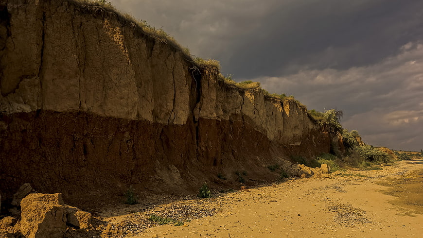 Dramatic Erosion Cliff Face Under Stormy Sky