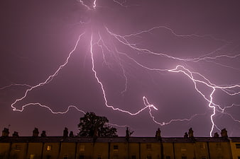 Dramatic Purple Lightning Storm Over Residential Rooftops