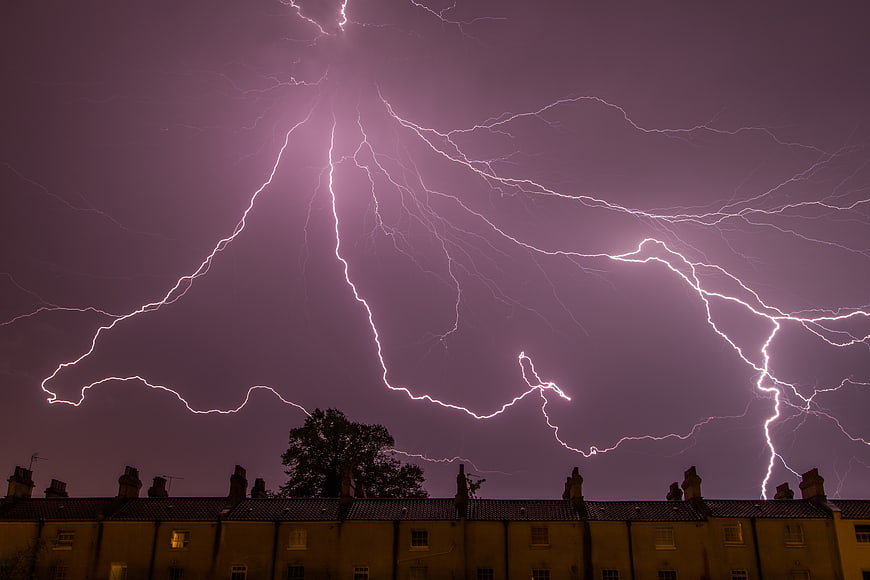Dramatic Purple Lightning Storm Over Residential Rooftops