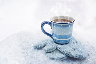 Steaming Blue Coffee Mug on Snow with Knitted Mittens