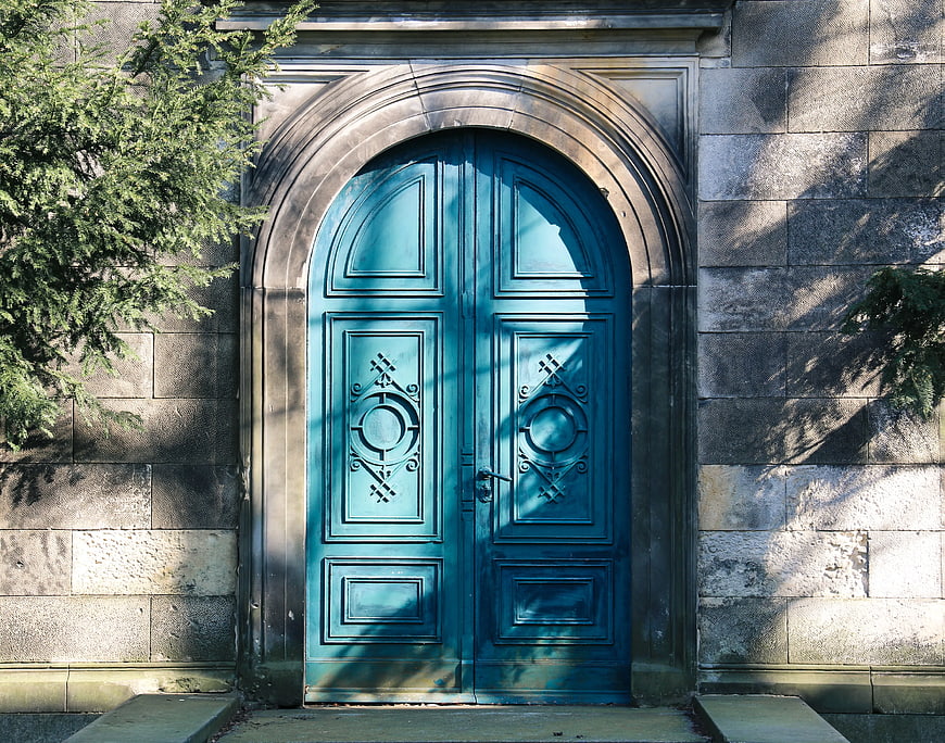 Ornate Blue Arched Door in Stone Wall
