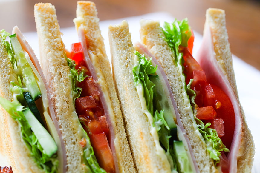 Close-up of fresh club sandwich with ham, lettuce, and tomato